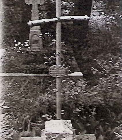 Grób oznaczony metalowym krzyżem na dwustopniowym cokole. Krzyż ma zgrubienia przypominające drzewo i zakończony jest guzkami. Inskrypcja na owalnej metalowej tabliczce u podstawy.