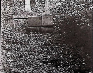 Grób oznaczony poziomą płytą nagrobną z prostym krzyżem, umieszczoną na cokole z centralną tablicą. Częściowo zachowane ogrodzenie z czterema betonowymi słupami połączonymi żeliwnymi prętami.