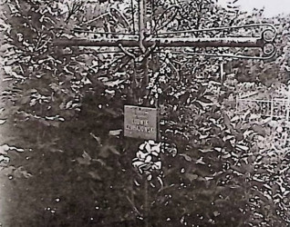 Żeliwny krzyż na betonowym cokole z motywami esownic i dwoma kołami z krzyżykiem. Na przecięciu figura Chrystusa; poniżej metalowa tabliczka z inskrypcją.