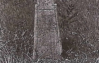 Nagrobek z krzyżem na cokole. Krzyż rozszerza się u dołu, z ramionami zakończonymi trójliściem. Cokół zwęża się ku górze, przechodząc w krzyż. Na dolnej belce wyryta inskrypcja.