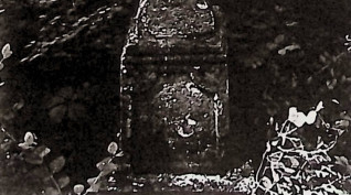 Nagrobek z krzyżem na cokole i podstawie. Krzyż fazowany, poszerzony u dołu, z wyrytym krzyżem na skrzyżowaniu ramion. Cokół prosty z płyciną inskrypcyjną, w górnych narożach dekorowaną ćwierćwałkami.