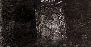 Nagrobek Joanny Fuczkiewicz z krzyżem na zwężającym się cokole. Płycina z przodu zamknięta łukiem dwulistnym z rytą inskrypcją.