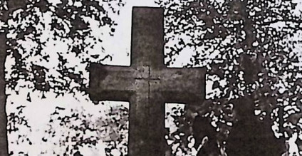 Nagrobek Jana Golańskiego z fazowanym krzyżem na cokole. Krzyż ma zwężającą się belkę pionową i wyryty krzyż na skrzyżowaniu ramion. Powyżej inskrypcja INRI.