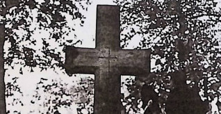 Nagrobek Jana Golańskiego z fazowanym krzyżem na cokole. Krzyż ma zwężającą się belkę pionową i wyryty krzyż na skrzyżowaniu ramion. Powyżej inskrypcja INRI.