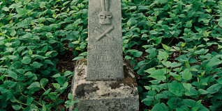 Nagrobek Michała Janickiego z krzyżem z reliefem ukrzyżowanego Chrystusa, titulusem i czaszką ze skrzyżowanymi piszczelami. Poniżej ryta inskrypcja.