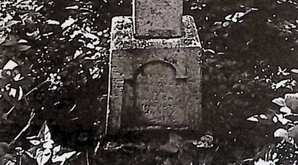 Nagrobek z fazowanym krzyżem na zwężającym się cokole. Na froncie płycina z łukowatą inskrypcją.