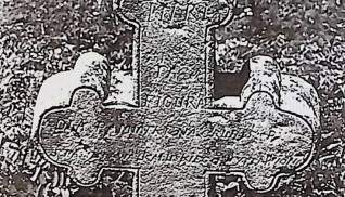 Nagrobek z krzyżem o zakończeniach w formie trójliścia. Krzyż ma żłobek i symetryczne półwałki u podstawy. Na powierzchni wyryta jest inskrypcja.