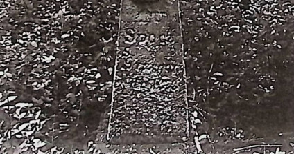 Grób oznaczony krzyżem na prostym cokole. Krzyż z reliefem ukrzyżowanego Chrystusa i titulusem. Ramiona krzyża zakończone trójliściem, poniżej symetryczne półwałki i ryt inskrypcyjny.