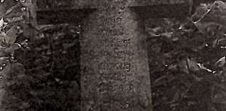 Nagrobek Karoliny Szychowskiej z krzyżem na cokole. Krzyż fazowany z inskrypcją INRI na ramionach i rytą inskrypcją na pionowej belce. Cokół prosty.