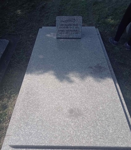 Nagrobek Jana i Marii Dziewońskich z tablicą inskrypcyjną z wyrytym liściem i czarnymi literami. Tablica pochylona do tyłu, wsparta na podpórce. Gzyms nagrobka szerszy od pozostałych elementów.