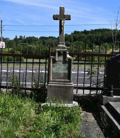 Grób oznaczony krzyżem na cokole z tablicą inskrypcyjną. Marmurowa podstawa wspiera cokół zakończony uskosem, z fryzem arkadowym i rytą inskrypcją. Krzyż ma sfazowane ramiona. Otoczony betonową opaską.