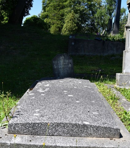 Nagrobek rodziny Hansel z tabliczką z piaskowca z inskrypcjami z obu stron, przymocowaną do dwustopniowej płyty nagrobnej z betonu i lastryko za pomocą żelaznych prętów.