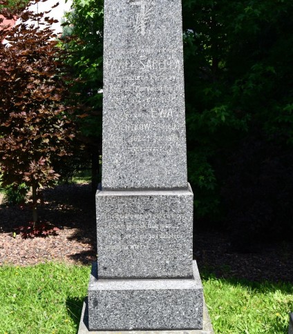 Nagrobek rodziny Sabella z obeliskiem na dwustopniowej podstawie. Na froncie wyryty krzyż i gałązka palmowa, poniżej inskrypcje. Podstawa zdobiona groszkowaniem.