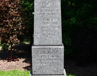 Nagrobek rodziny Sabella z obeliskiem na dwustopniowej podstawie. Na froncie wyryty krzyż i gałązka palmowa, poniżej inskrypcje. Podstawa zdobiona groszkowaniem.