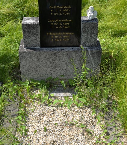 Grób oznaczony polerowaną stelą z inskrypcjami dla Emila Macháčka, Julii Macháčkovej i Hildegardy Mattlovej. Na prawym postumencie porcelanowa figurka aniołka. Otoczony trawą i żwirem.
