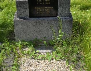 Grób oznaczony polerowaną stelą z inskrypcjami dla Emila Macháčka, Julii Macháčkovej i Hildegardy Mattlovej. Na prawym postumencie porcelanowa figurka aniołka. Otoczony trawą i żwirem.