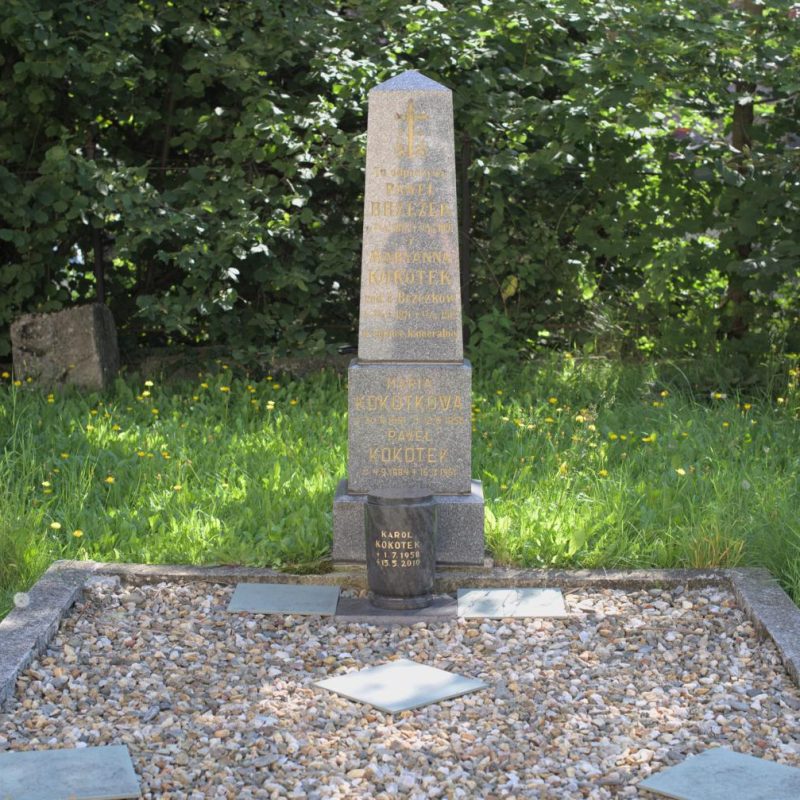 Tombe familiale des Brzezek et Kokotek avec un obélisque poli sur une base à deux niveaux et une urne moderne. Les inscriptions sont gravées et dorées. La zone de la tombe est bordée d'une bande et de carreaux en céramique.