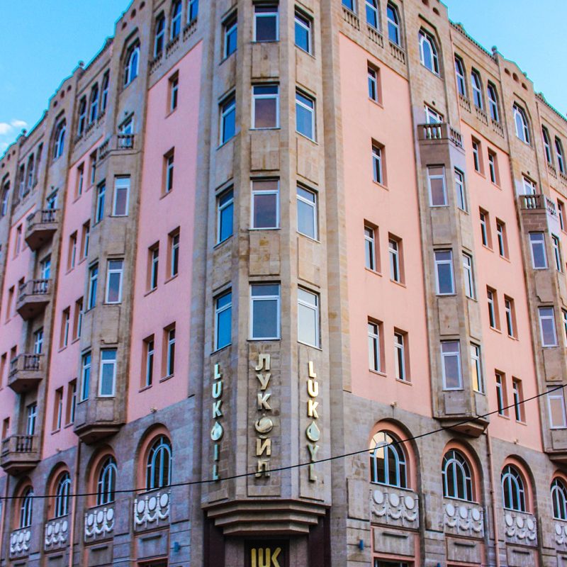 Budynek dawnego hotelu 'Nowa Europa' w Baku, zaprojektowany przez polskiego architekta Józefa Płoszkę. Sześciopiętrowa konstrukcja ma różową elewację z beżowymi detalami kamiennymi i oznaczeniami 'Lukoil'.