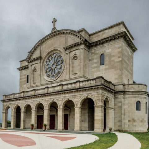 Façade de l'église Saint-Jean de Dieu à Chicago, avec un design à deux tours, une galerie voûtée et une rosace représentant Sainte Cécile. Le bâtiment combine des éléments Renaissance et Baroque.