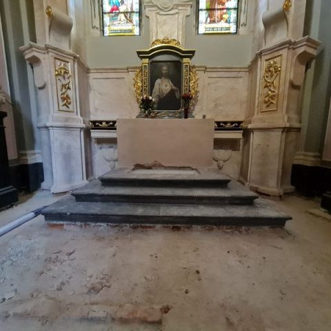Intérieur de la chapelle de Jésus Crucifié dans la cathédrale latine de Lviv, montrant l'autel avec des marches et une peinture au-dessus. Le sol est en rénovation, avec des matériaux de construction visibles.
