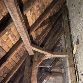 Structure en bois de la charpente de la cathédrale arménienne à Lviv, montrant des poutres et des planches lors des travaux de restauration.
