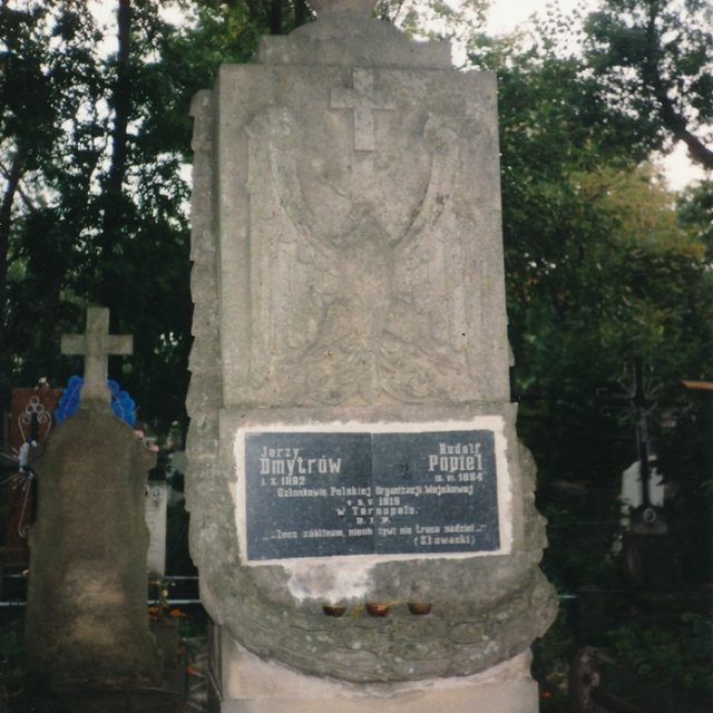 Nagrobek Jerzego Dmytrówa i Rudolfa Popiela, członków Polskiej Organizacji Wojskowej, rozstrzelanych w 1919 roku. Kamień z inskrypcjami i krzyżem, otoczony drzewami.