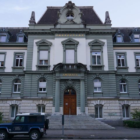 Façade du bâtiment Amthaus à Bienne, avec un avant-corps central, un toit mansardé et des éléments décoratifs, illustrant l'architecture historiciste tardive.