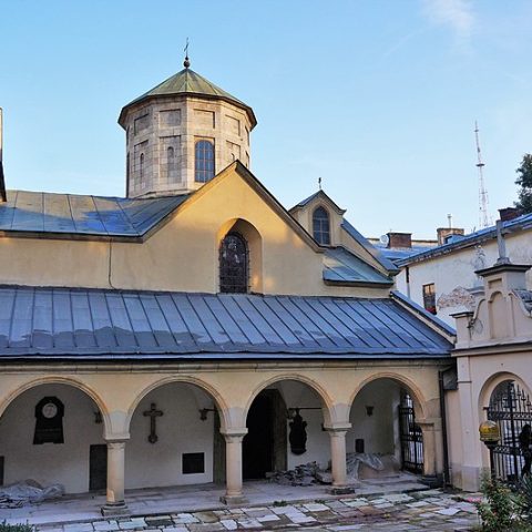 Вірменський собор у Львові з характерним куполом та арковим подвір’ям. Будівля має світлий фасад і оточена іншими спорудами.