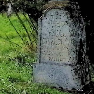 Nagrobek Pawła Grześkowa z krzyżem na dwustopniowym cokole. Krzyż z wykrojem łuku i medalionem z napisem 'INRI'. Podstawa i krzyż groszkowane. Z przodu płycina z rytą inskrypcją.