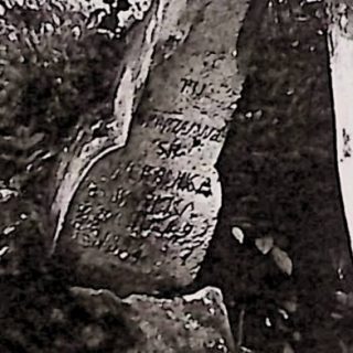 Grób oznaczony fazowanym krzyżem na cokole z rytą inskrypcją. Cokół z płyciną zamkniętą pełnym łukiem z dodatkowymi inskrypcjami.