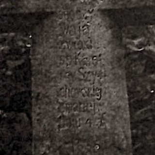 Nagrobek Karoliny Szychowskiej z krzyżem na cokole. Krzyż fazowany z inskrypcją INRI na ramionach i rytą inskrypcją na pionowej belce. Cokół prosty.
