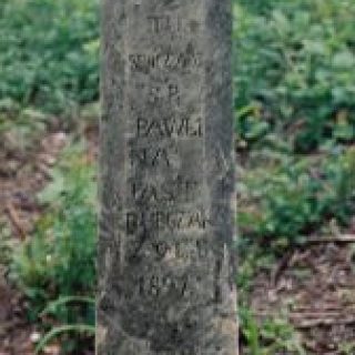 Gravestone of Pawlina Jastrubczak with a cross on a pedestal. The cross is beveled on a small base. At the intersection of the arms, a cross is carved above the inscription INRI, with an engraved inscription below.