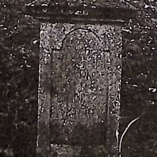 Pierre tombale de Florya et Rozalia Kałuski avec une croix sur un piédestal. La croix est chanfreinée et le piédestal est haut avec un sommet profilé. Le devant a un panneau arqué avec une inscription gravée.