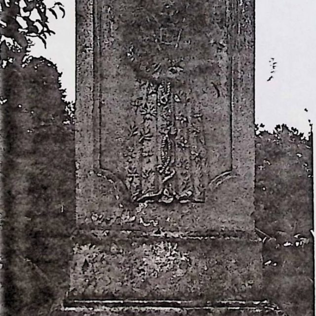Stone tombstone of Adam Jełowiecki with a damaged top. The base is two-part with a rectangular pedestal featuring a relief of Christ in a long robe with plant motifs and a crown of thorns.