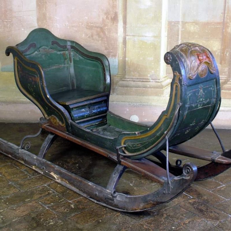 Dark green lacquered wooden sleigh from the 18th century with floral decorations, located in Palazzo Albergatti, Zola Predosa. Gifted by Queen Maria Kazimiera Sobieska to the Albergatti family.