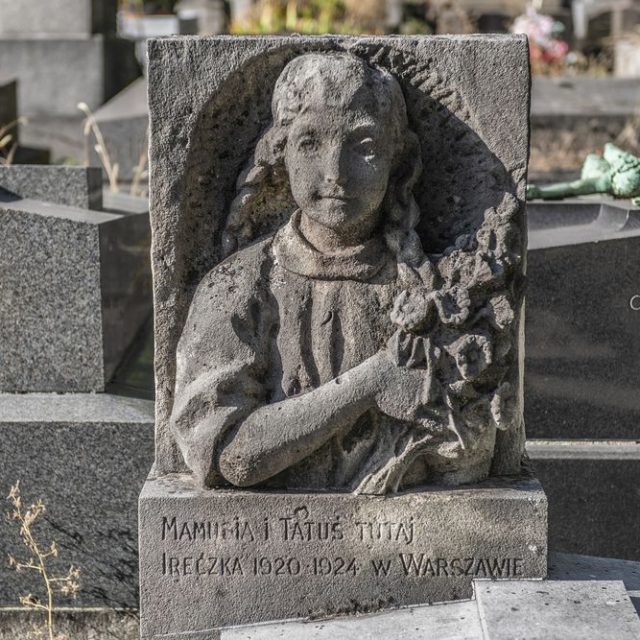 Pierre tombale en calcaire d'Ireczka Kędzierska-Berthier par Alina Szapocznikow à Paris. Représente une fille avec des tresses tenant des fleurs, inscrit 'MAMUSIA I TATUŚ TUTAJ / IRECZKA 1920-1924 W WARSZAWIE'.