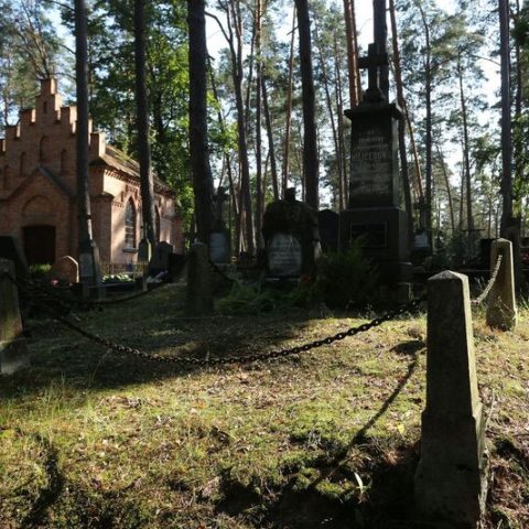 Grób Franciszki Milicerowej i Marii Pereświet Sołtan z dwupoziomowym krzyżem granitowym i tabliczką inskrypcyjną, otoczony granitowymi słupkami i żelaznymi łańcuchami, na cmentarzu leśnym.