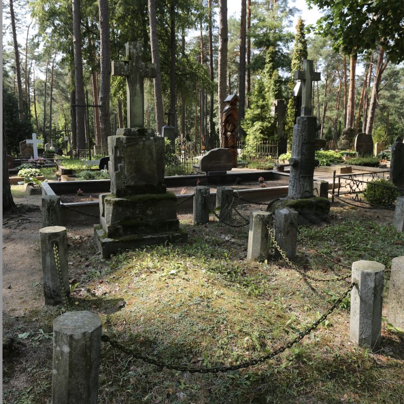 Grób z piaskowcowym krzyżem na cokole w formie skałek, otoczony ogrodzeniem z ośmiokątnych słupków betonowych z żelaznymi łańcuchami. Tablica inskrypcyjna w kształcie zwoju papirusu.