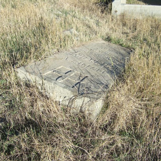 Pierre tombale trapézoïdale d'Elżbieta Wiercińska avec inscription en polonais, posée sur une base maçonnée, entourée d'herbe.