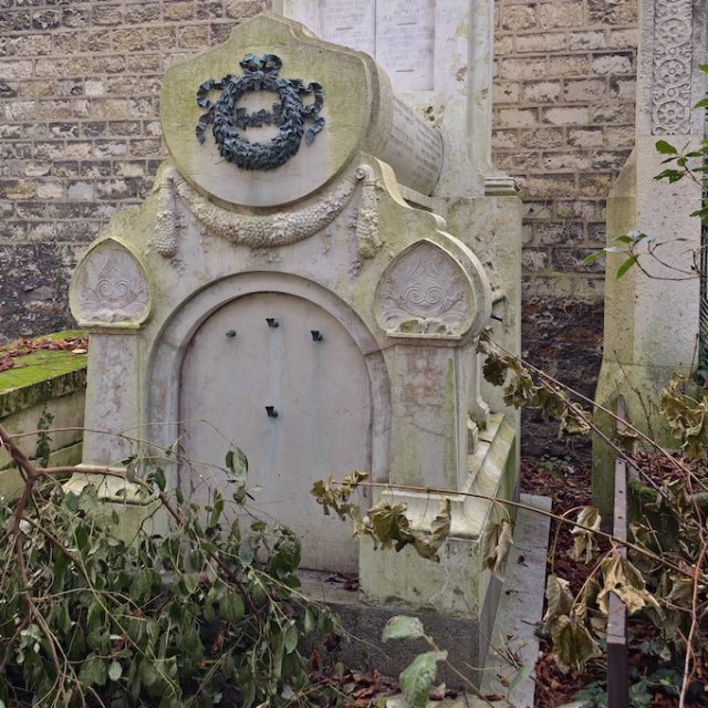 Tomb of the Fould and Pinchas Borenstein family with a semicircular cover, bronze wreath, and Corinthian pilasters. Relief plant motif in the tympanum. Inscription visible on the stele.