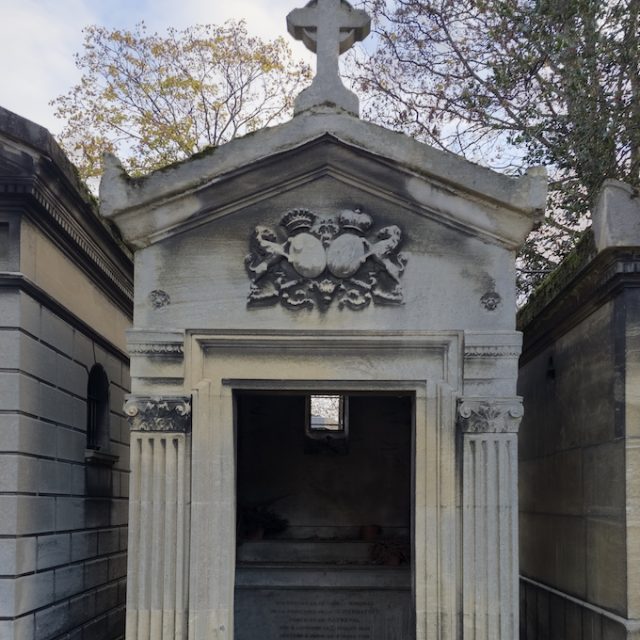 Tombeau de la famille de Rayneval avec pilastres cannelés et chapiteaux corinthiens, murs à refends, toit à deux versants, acrotères surmontés d'une croix. Deux blasons dans le tympan, autel à l'intérieur, pas de portes d'entrée.
