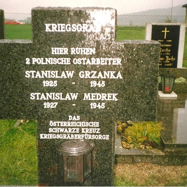 Grave of two Polish forced laborers, Stanisław Grzanka and Stanisław Mędrek, in Bocksdorf, Austria. Granite cross with German inscription detailing their names and dates of birth and death.