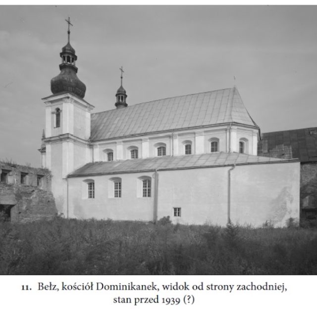 Widok zachodni kościoła pw. Niepokalanego Poczęcia NMP w Bełzie, z dwukondygnacyjną fasadą z wieżami i dachem dwuspadowym, otoczony zarośniętą roślinnością, przed 1939 rokiem.