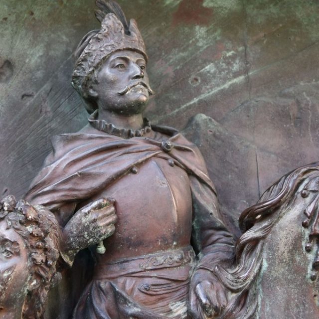 Bas-relief en bronze sur le monument dédié à Ivan Gundulić à Dubrovnik, représentant un personnage historique coiffé d’un panache et revêtu d’une armure, probablement Ladislas IV, à cheval. À côté, on aperçoit un personnage plus petit aux cheveux bouclés.