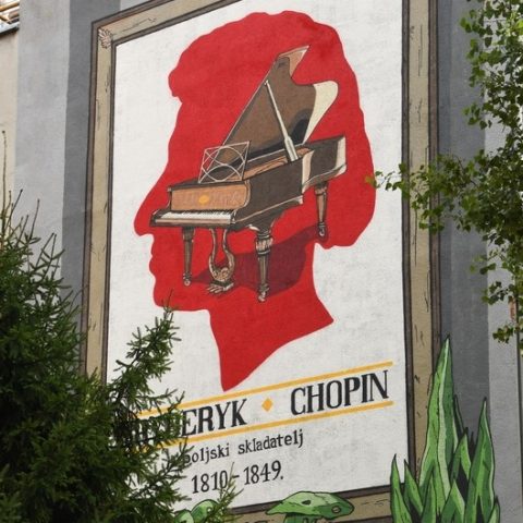 Mural w Zagrzebiu przedstawiający fortepian w sylwetce głowy Fryderyka Chopina, otoczony ramą i zielenią. Poniżej napis 'Fryderyk Chopin, polski kompozytor, 1810-1849.'