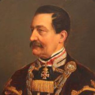 Portrait du baron Metel Ožegović, vêtu d'un uniforme sombre richement orné de médailles, représenté de profil sur un fond neutre. La lumière met en valeur son visage et les détails de son uniforme.