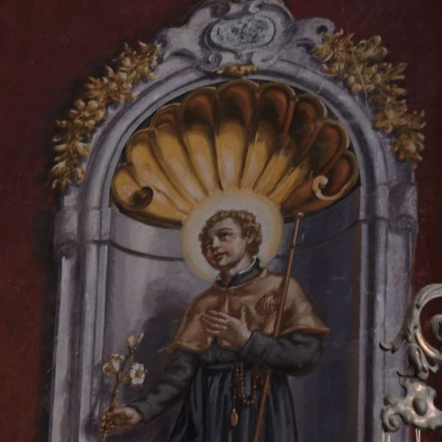 Fresco of St. Stanislaus Kostka in a niche with a shell motif in the Church of St. Ignatius in Dubrovnik. He wears a Jesuit habit, holds a lily in his right hand, and a staff in his left arm.