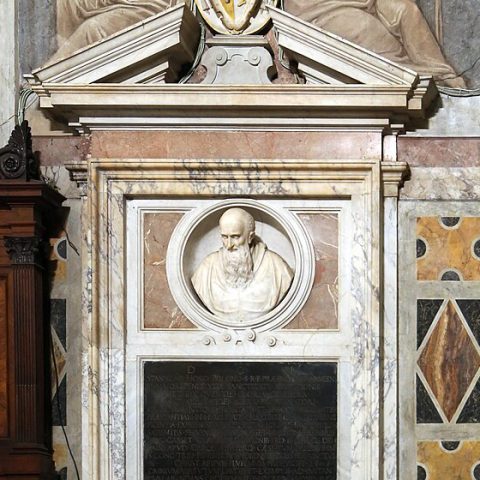 La tombe du cardinal Stanisław Hozjusz dans la basilique Santa Maria in Trastevere à Rome. La tombe comporte un buste en marbre de Hozjusz dans une niche ovale, avec une inscription en dessous et des éléments décoratifs tout autour.