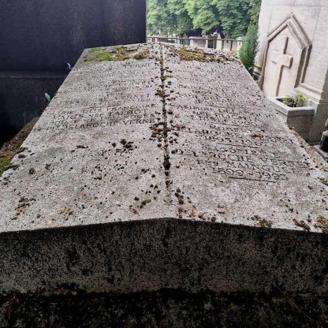 Nagrobek rodzin Delaroche i Plichta z dwuspadową płytą i rytymi inskrypcjami. Powyżej inskrypcji płytko ryte krzyże łacińskie. Na bokach metalowe uchwyty z motywem palmety.
