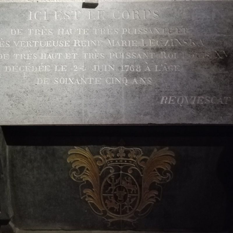 Płyta nagrobna Marii Leszczyńskiej w bazylice Saint-Denis z inskrypcją po francusku i herbem z pięciopolową tarczą polsko-litewską z orłem i głową byka.